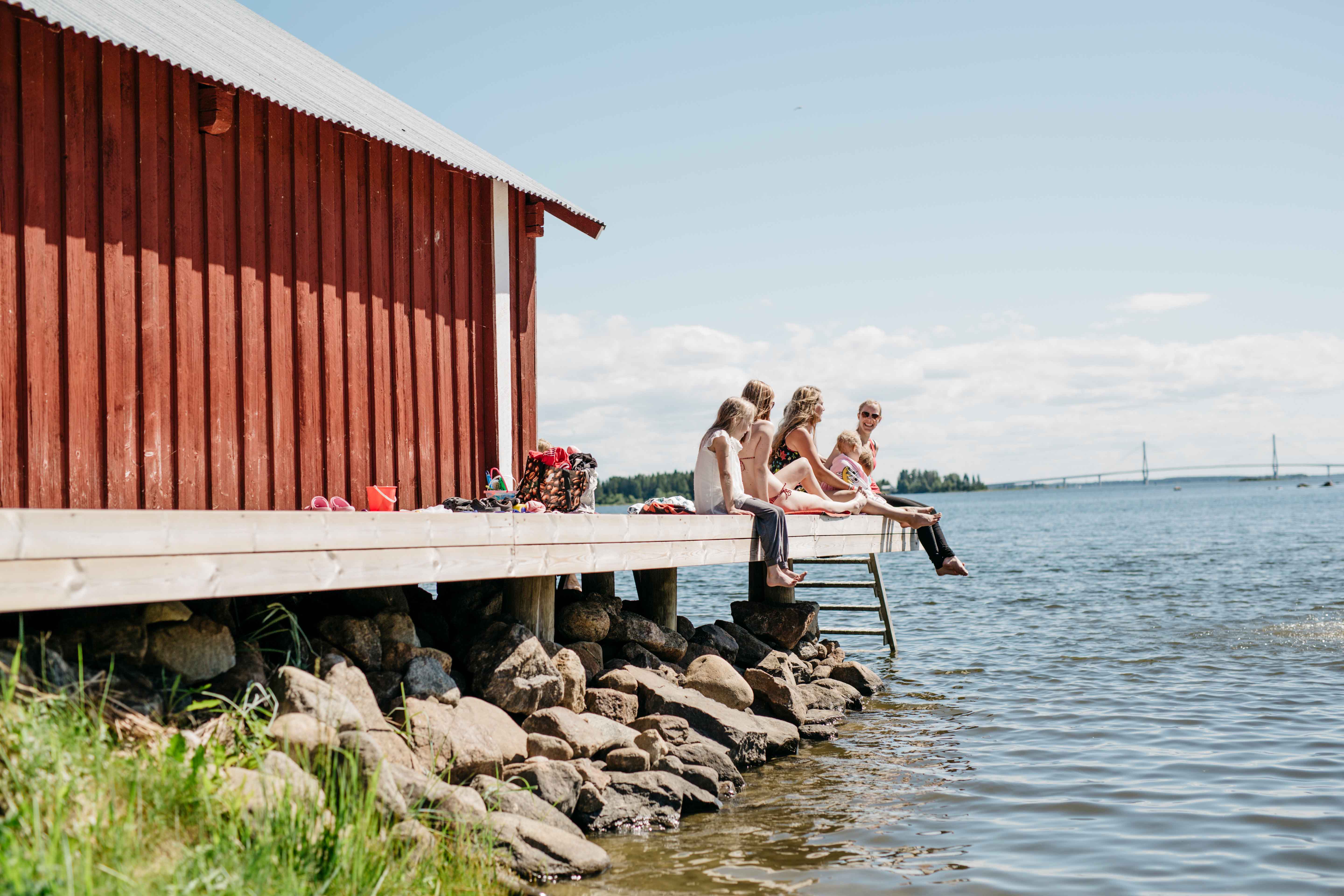 Familia disfrutando de su tiempo libre en un muelle en el archipiélago de Finlandia