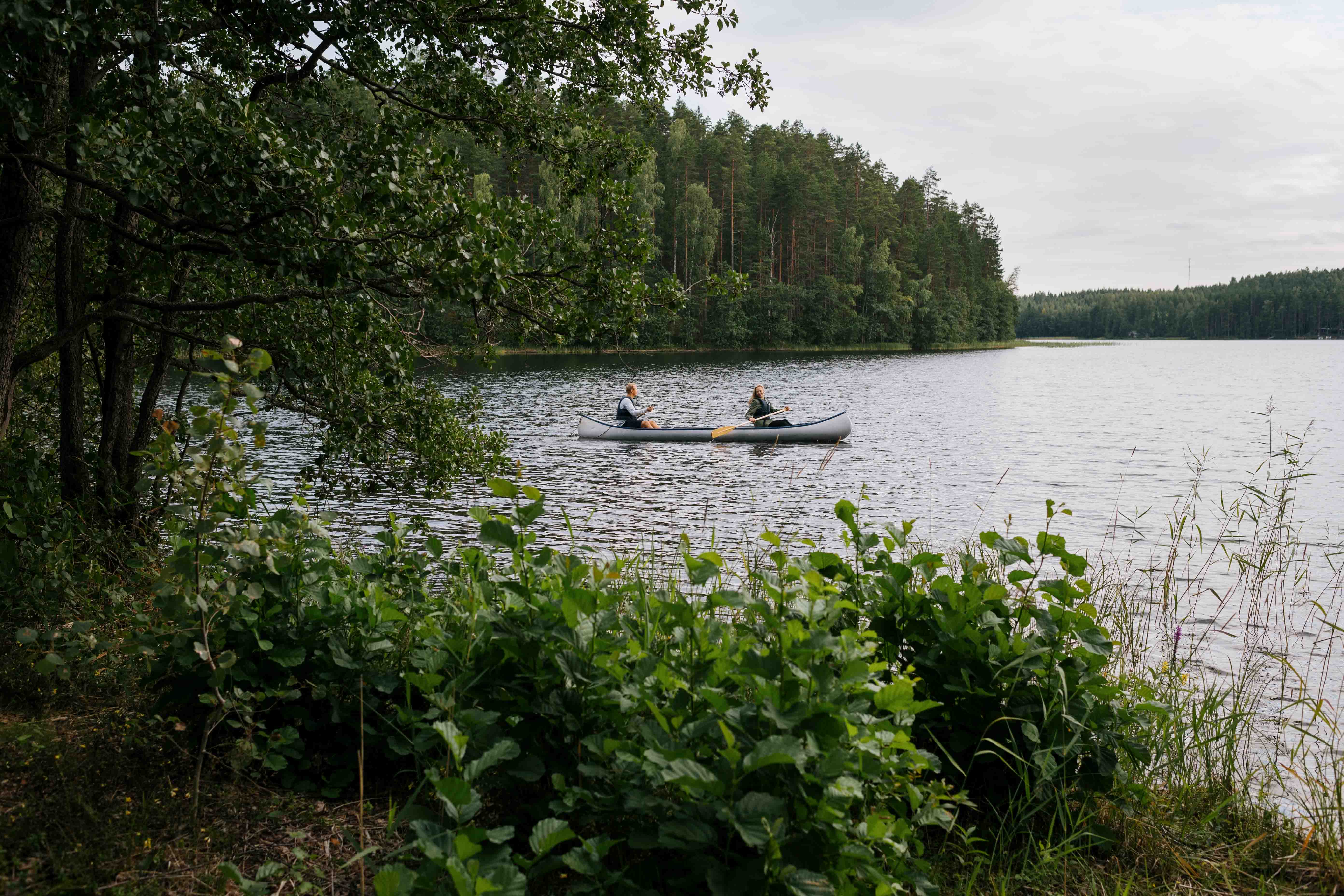 Personen, die auf einem See in Finnland paddeln.