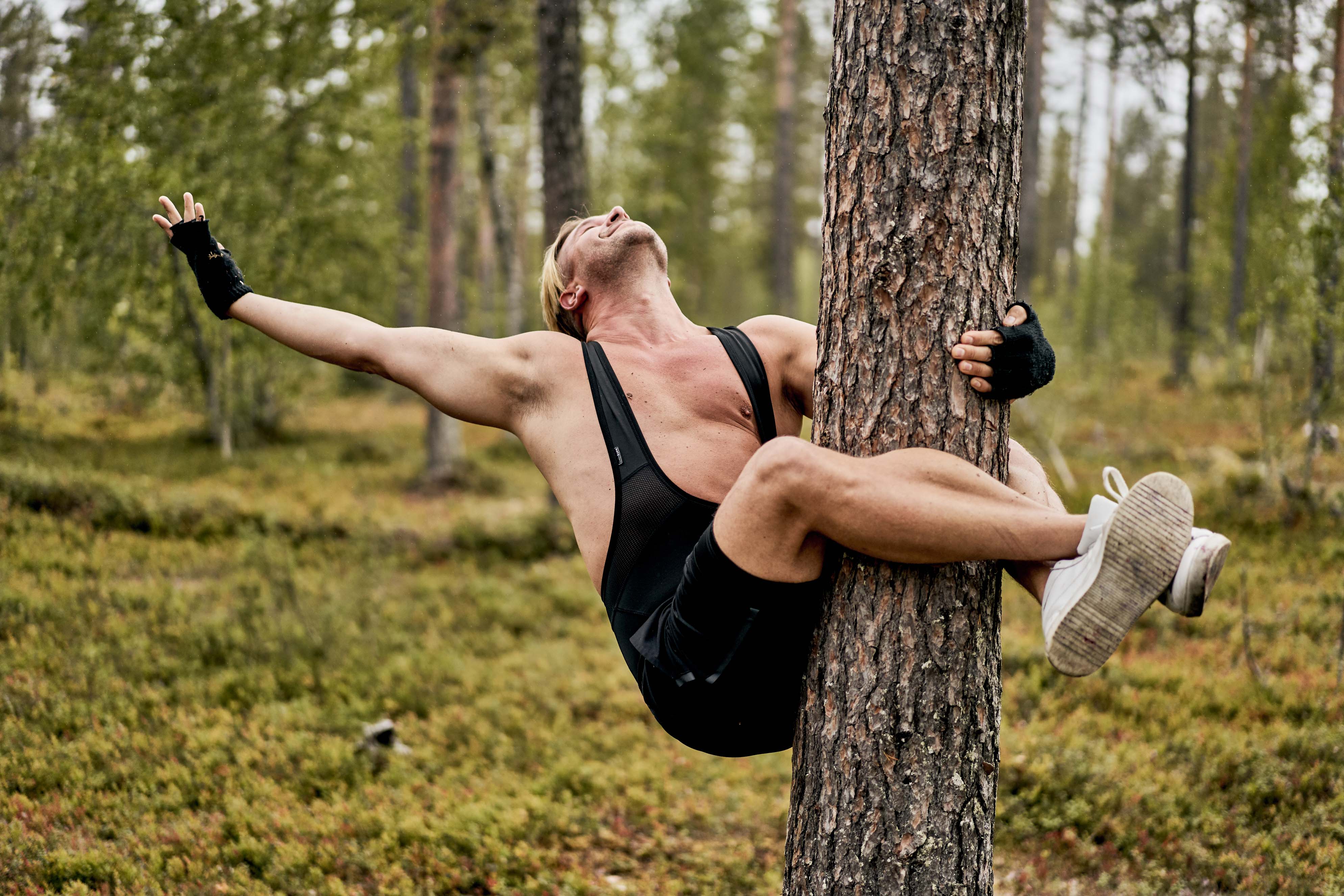 Person umarmt einen Baum in Finnland.