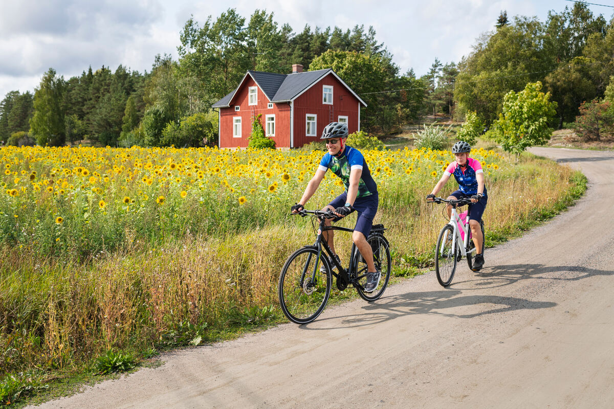 Two people cycling on a gravel road in Finland